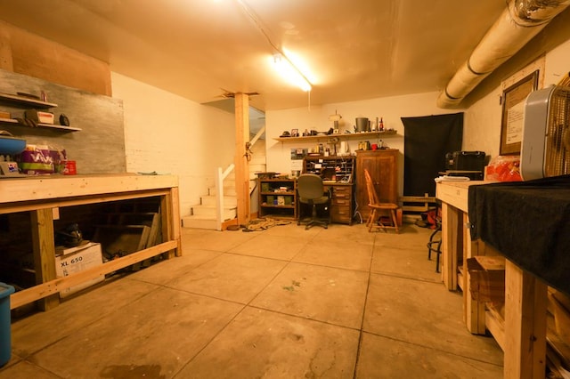 basement with tile patterned floors and a workshop area