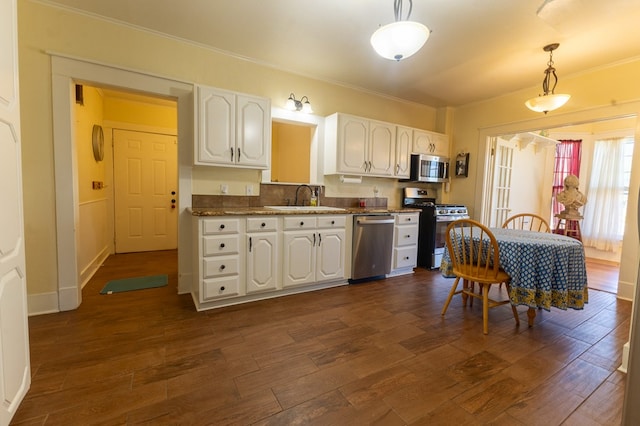 kitchen featuring white cabinetry, dark hardwood / wood-style flooring, hanging light fixtures, and appliances with stainless steel finishes