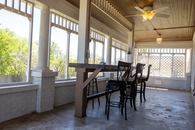 sunroom featuring ceiling fan and ornate columns