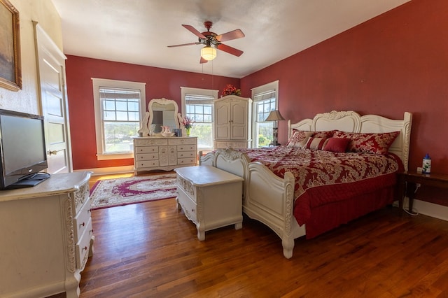 bedroom with dark hardwood / wood-style flooring and ceiling fan