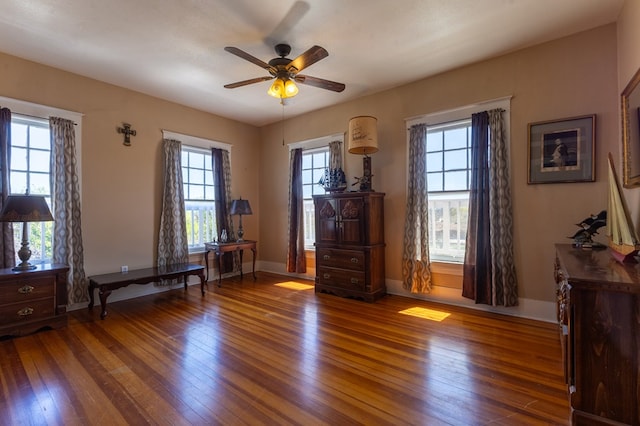 unfurnished room with ceiling fan, dark hardwood / wood-style flooring, and a wealth of natural light