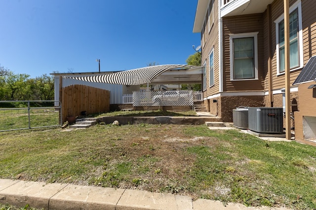 view of side of home featuring a lawn and cooling unit