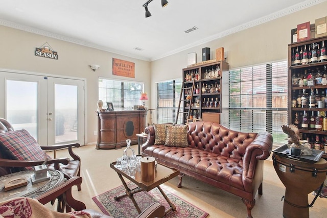 living room with ornamental molding, french doors, and carpet