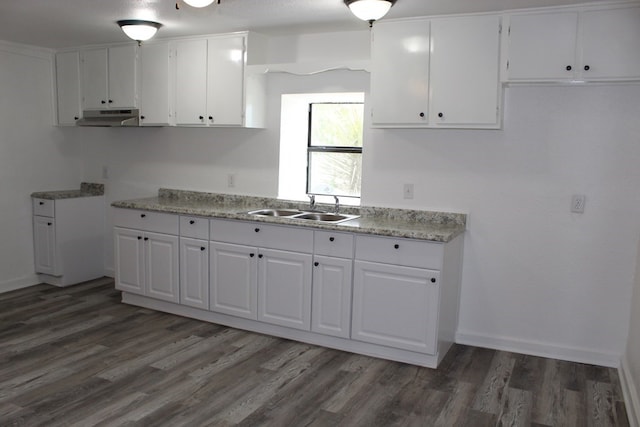 kitchen with white cabinetry, sink, light stone countertops, and dark hardwood / wood-style floors