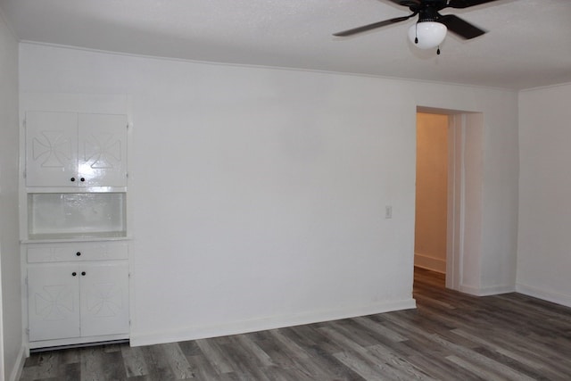 spare room featuring dark hardwood / wood-style flooring, crown molding, and ceiling fan