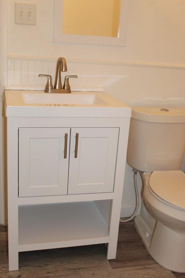 bathroom featuring vanity, hardwood / wood-style floors, and toilet