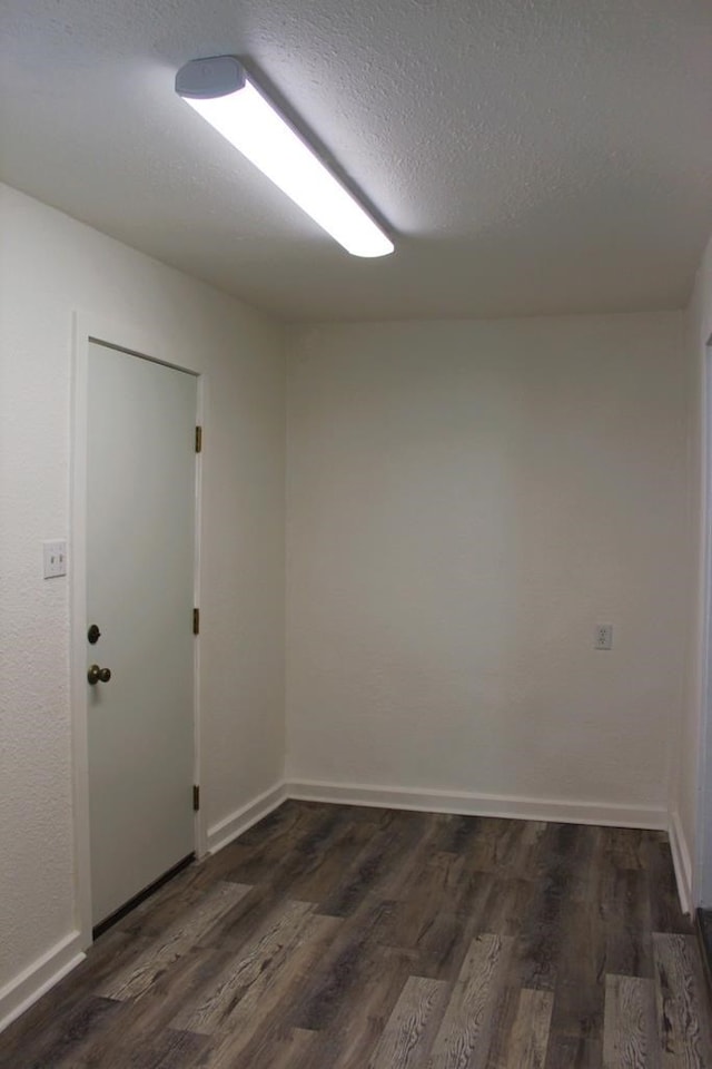 spare room with dark hardwood / wood-style flooring and a textured ceiling