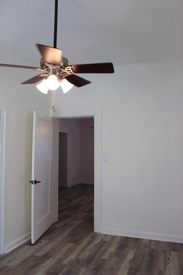 spare room featuring dark wood-type flooring and ceiling fan