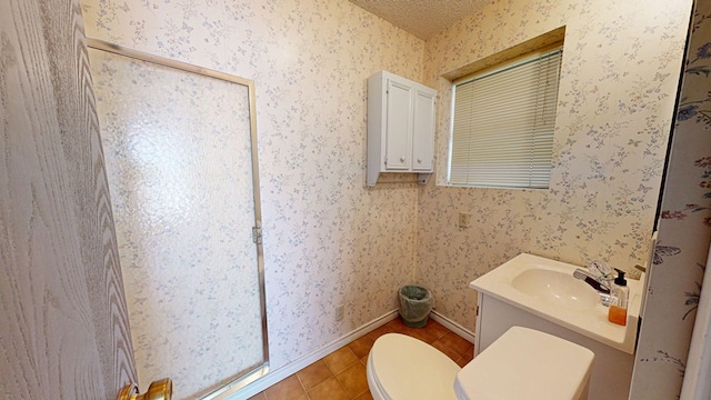 bathroom with tile patterned flooring, vanity, toilet, and a textured ceiling