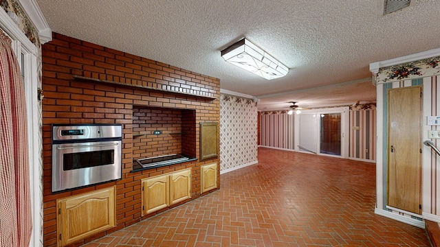 kitchen featuring ornamental molding, a textured ceiling, and appliances with stainless steel finishes