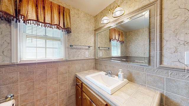 bathroom with plenty of natural light, tile walls, and vanity