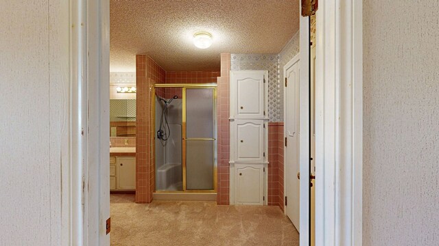 bathroom with a textured ceiling and an enclosed shower