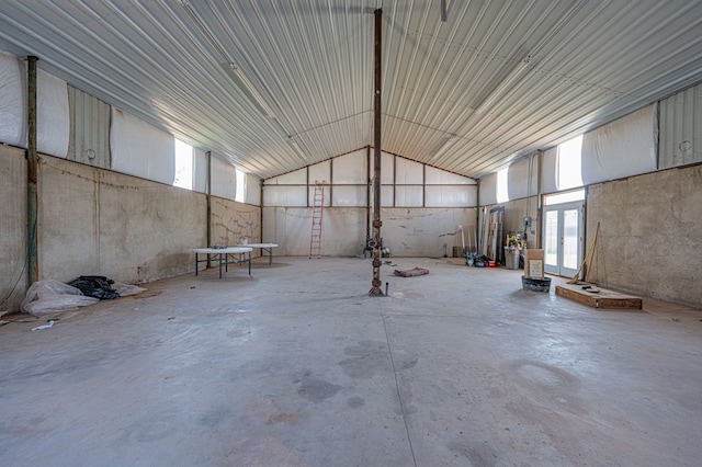 miscellaneous room with concrete flooring and high vaulted ceiling