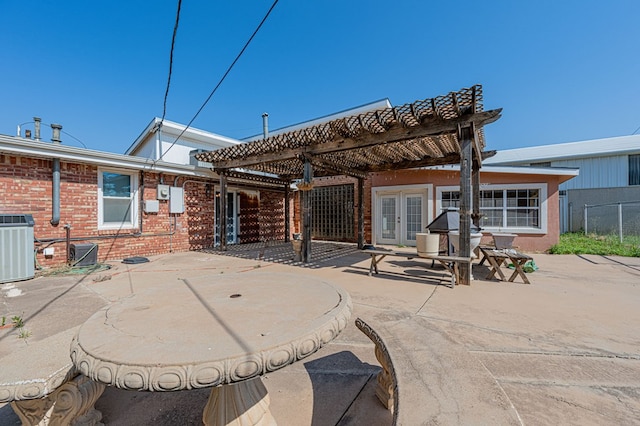 back of property with french doors, a pergola, central AC unit, and a patio area