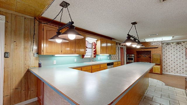 kitchen featuring decorative light fixtures, sink, kitchen peninsula, and stainless steel appliances