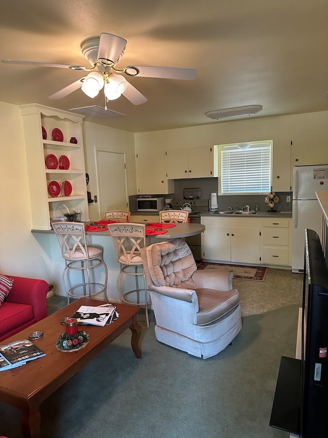 living room featuring carpet flooring, ceiling fan, and sink