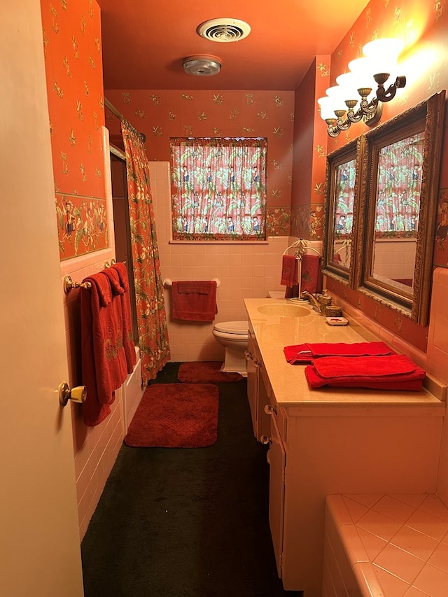 full bathroom featuring shower / bathtub combination with curtain, vanity, tile walls, and toilet