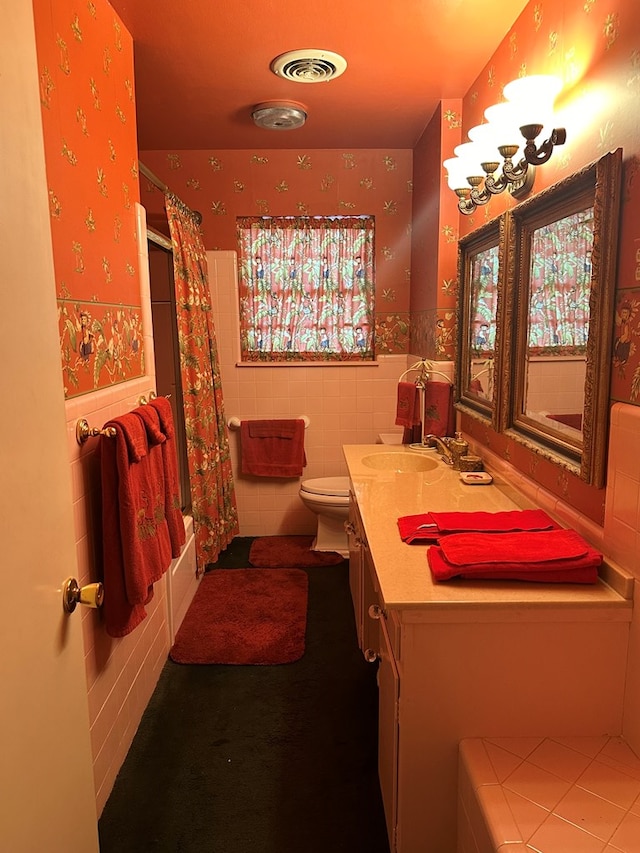 full bathroom featuring vanity, shower / bath combo, toilet, and tile walls