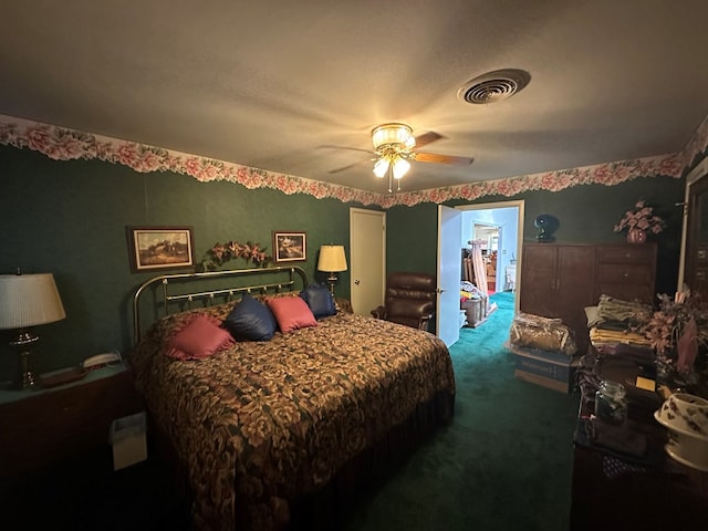 carpeted bedroom featuring ceiling fan and a walk in closet