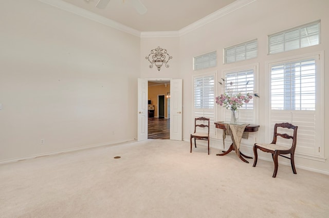 living area with baseboards, ornamental molding, carpet, and ceiling fan