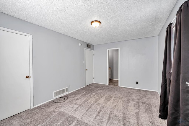 unfurnished bedroom featuring carpet and a textured ceiling