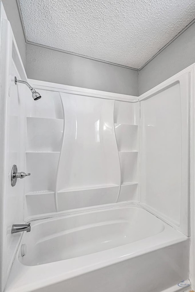 bathroom featuring bathing tub / shower combination and a textured ceiling