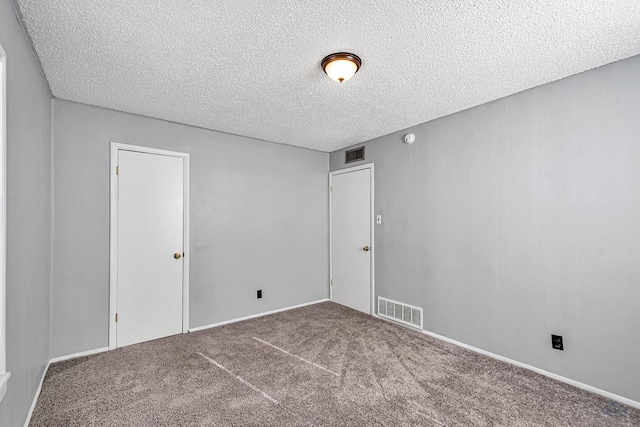 unfurnished room featuring carpet floors and a textured ceiling