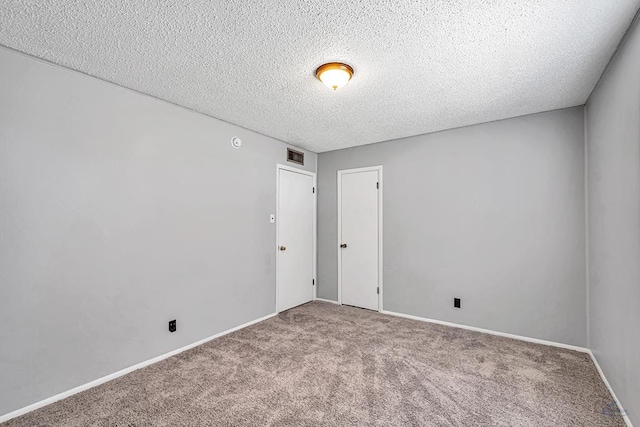 empty room featuring a textured ceiling and carpet floors