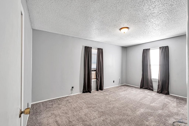 spare room featuring carpet floors and a textured ceiling