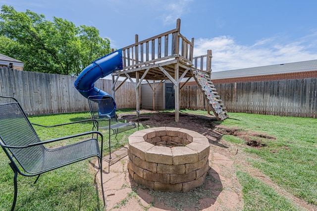 view of yard featuring a fire pit, a storage shed, and an outdoor structure