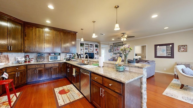 kitchen with dishwasher, open floor plan, a peninsula, a sink, and a ceiling fan