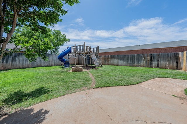 view of yard with a patio area, a fire pit, and a playground