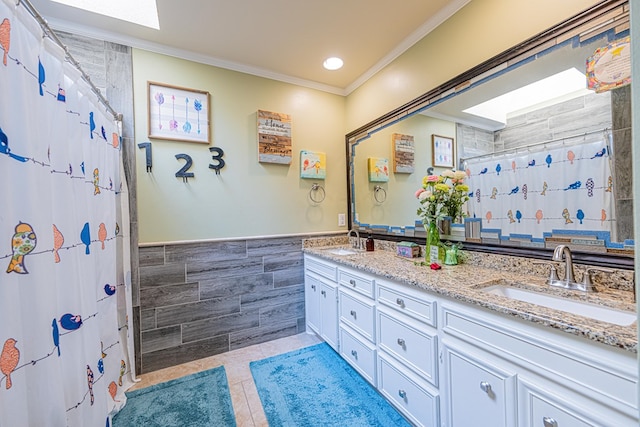 full bath featuring tile walls, crown molding, tile patterned floors, double vanity, and recessed lighting