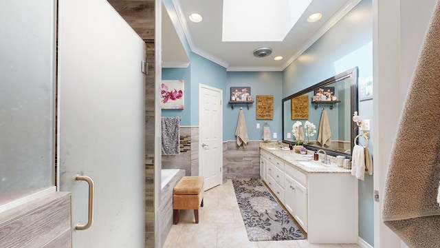 bathroom with crown molding, a skylight, tile walls, double vanity, and a garden tub