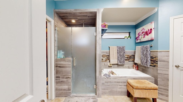 bathroom featuring a stall shower, a bath, ornamental molding, and tile walls