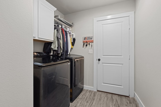 2602 Ivy Ln, Midland, TX 79705 - laundry room with washing machine and clothes dryer, light wood-type flooring, and cabinet space