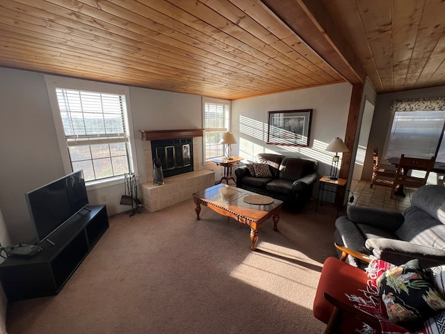 carpeted living room with a healthy amount of sunlight, a tiled fireplace, wood ceiling, and vaulted ceiling