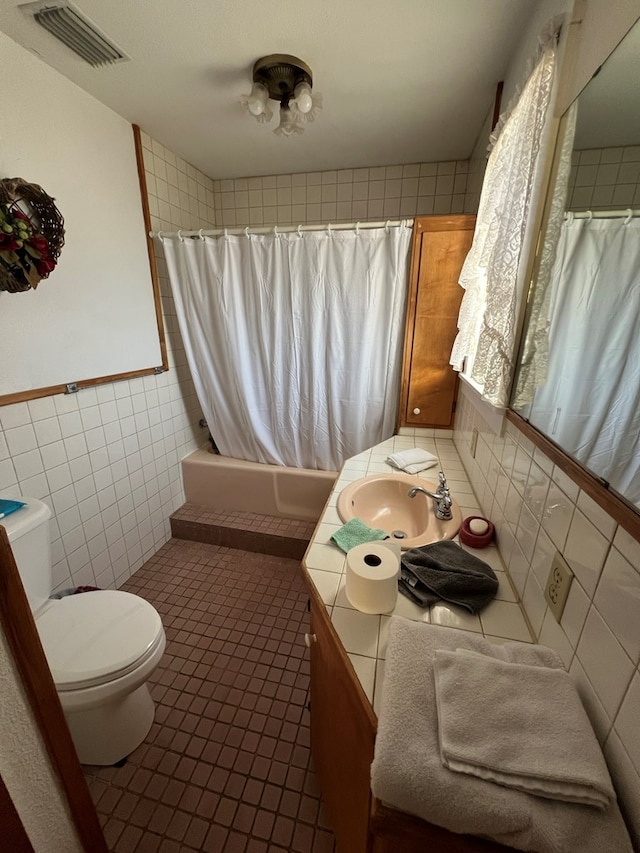 full bathroom featuring shower / tub combo, vanity, tile walls, tile patterned flooring, and toilet