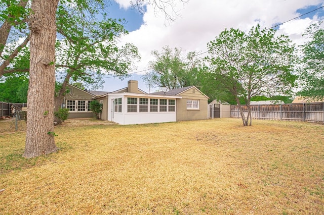 back of property with a sunroom and a chimney