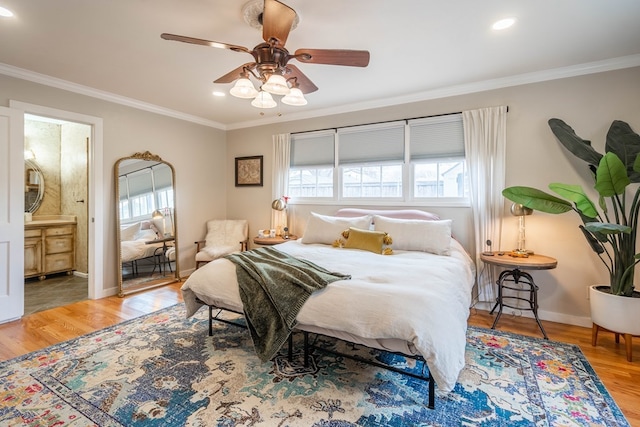 bedroom with crown molding, wood finished floors, recessed lighting, baseboards, and ensuite bath
