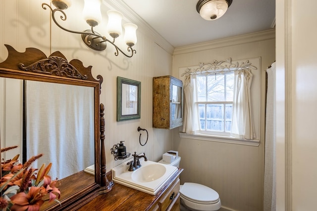bathroom with toilet, ornamental molding, and vanity