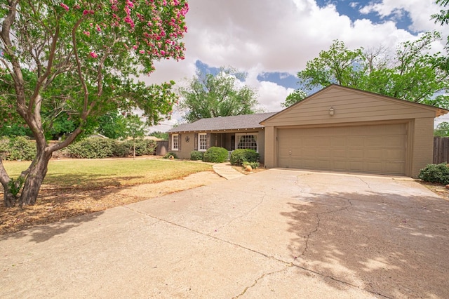 ranch-style house featuring concrete driveway, an attached garage, a front lawn, and brick siding