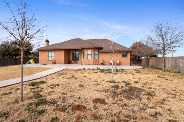 back of property featuring a playground and a patio area