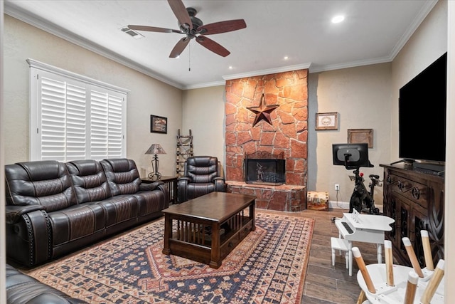 living room featuring hardwood / wood-style flooring, a fireplace, ornamental molding, and ceiling fan