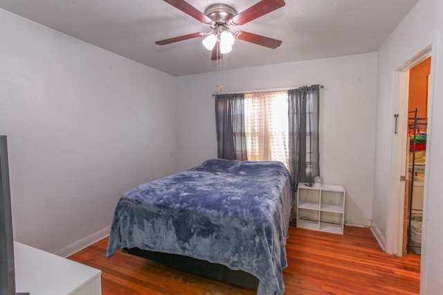 bedroom with baseboards, a ceiling fan, and wood finished floors