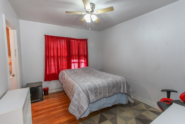 bedroom with baseboards, a ceiling fan, and wood finished floors