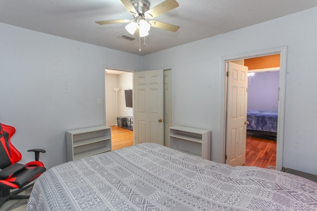 bedroom with visible vents, a ceiling fan, and wood finished floors