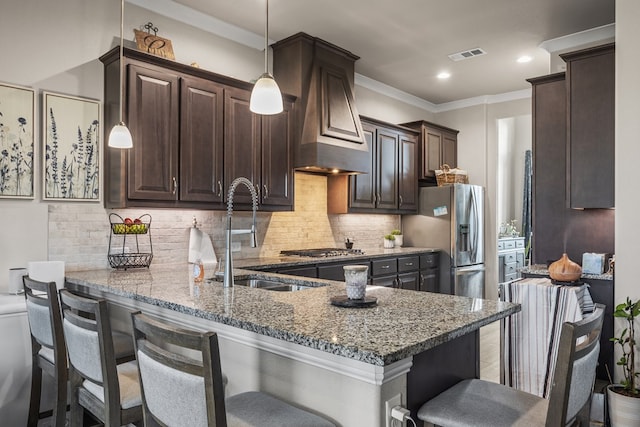 8421 E County Rd 115, Midland, TX 79706 - kitchen with a sink, dark brown cabinetry, a breakfast bar, light stone counters, and a peninsula