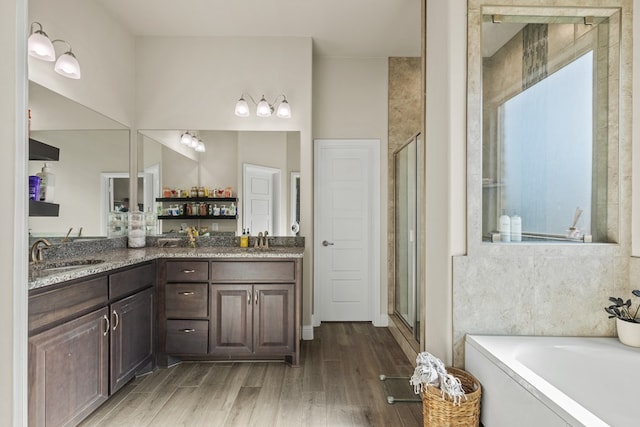 8421 E County Rd 115, Midland, TX 79706 - bathroom featuring wood finished floors, a stall shower, a garden tub, and double vanity