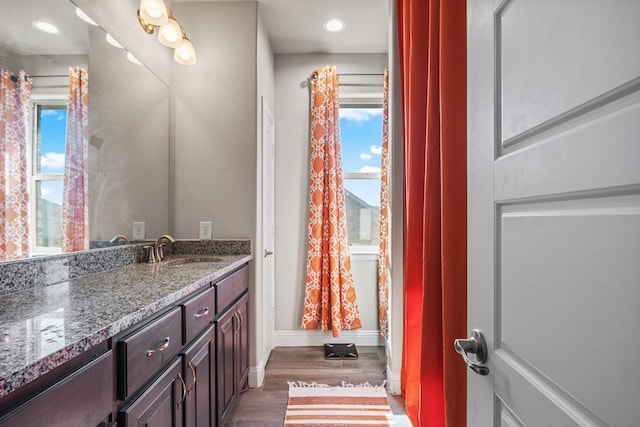 8421 E County Rd 115, Midland, TX 79706 - bathroom with wood finished floors, vanity, and baseboards